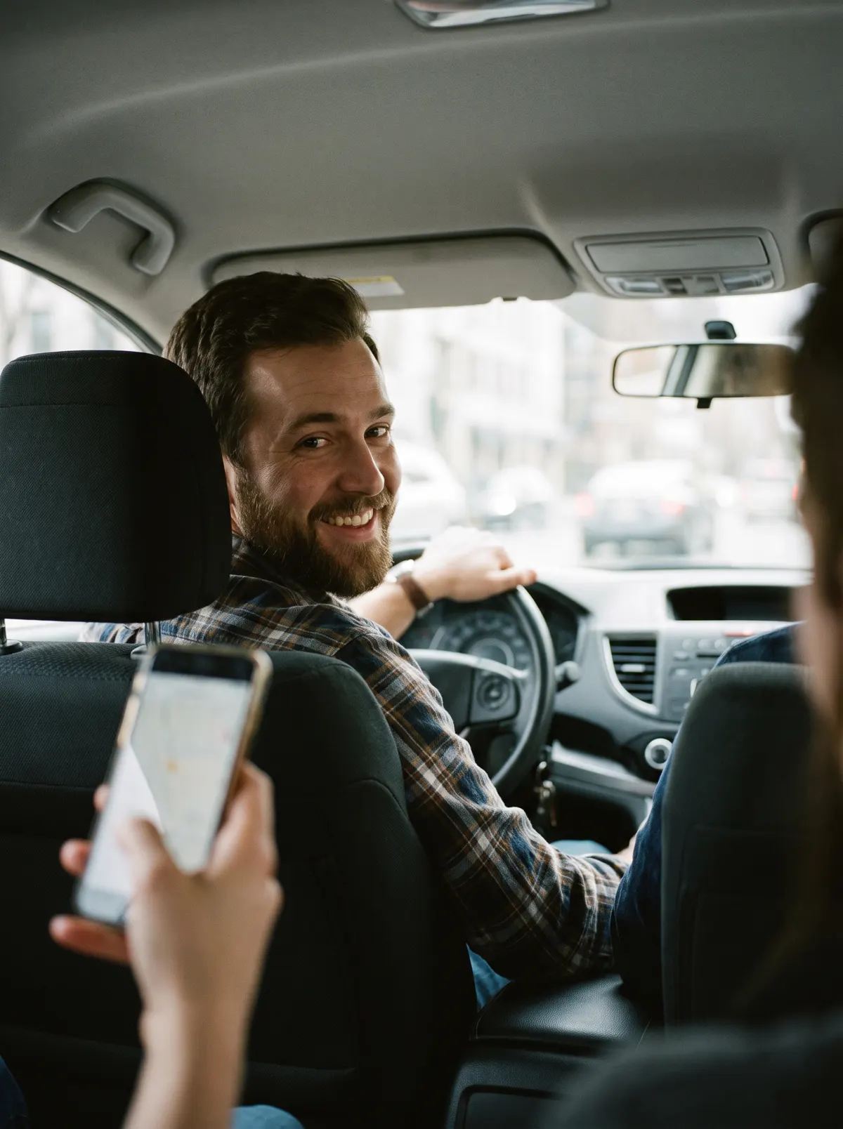 Passenger's view of a smiling driver in the car